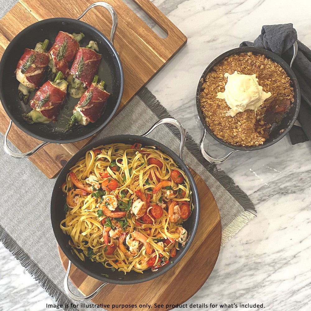Three dishes on a wooden board with colourful cookware beef rolls noodle stir-fry dessert - Baccarat