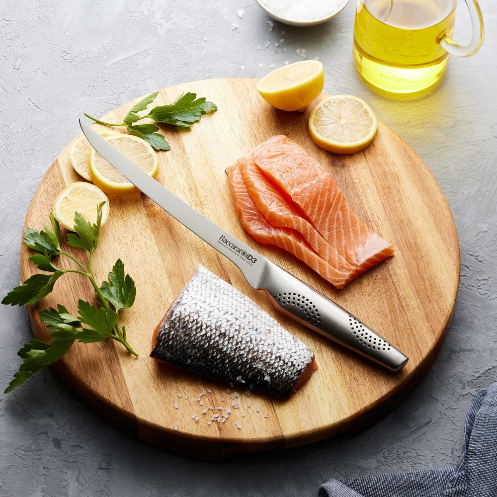 Sleek Baccarat Filleting Knife 20cm slicing salmon on a board with lemon slices and herbs