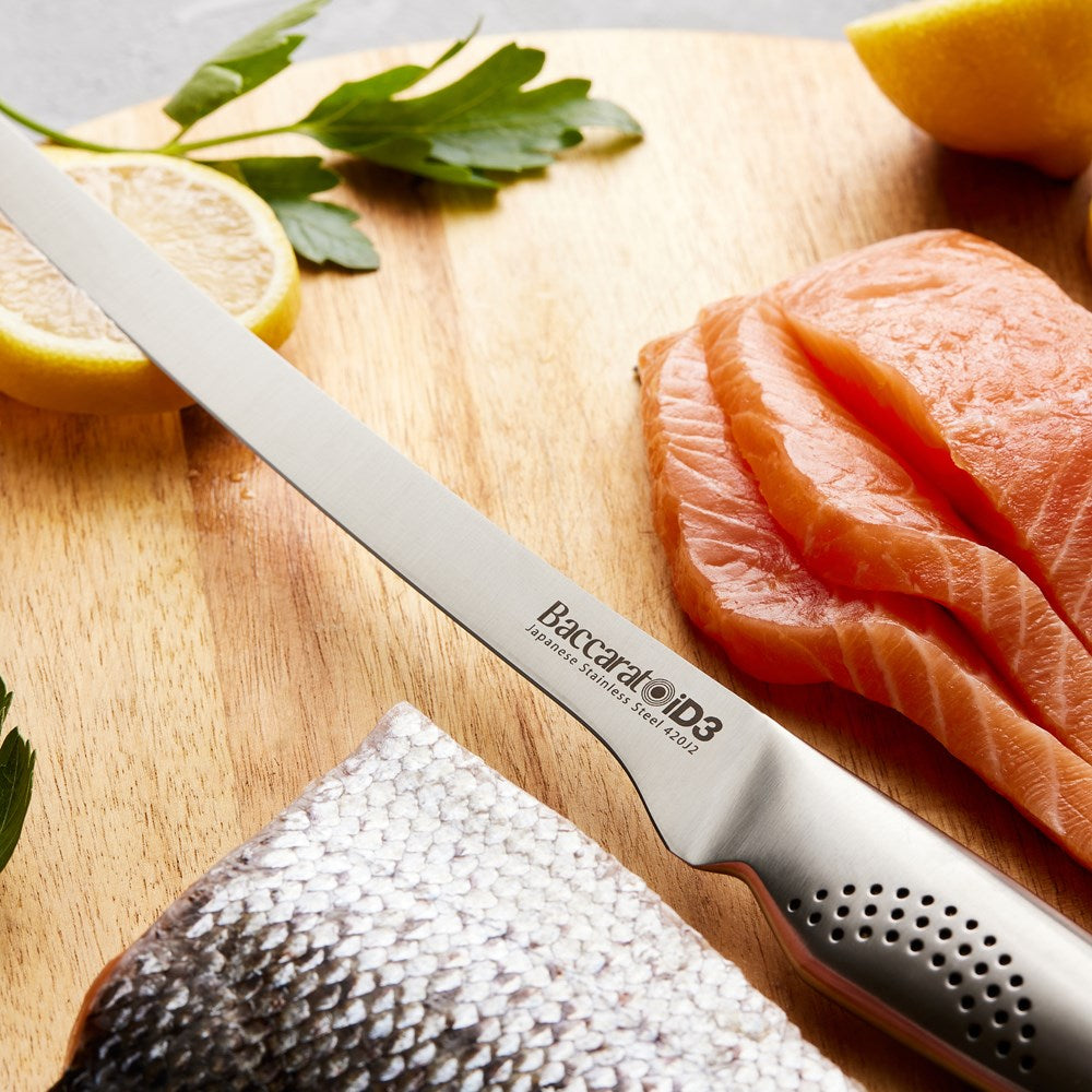 Sleek Baccarat Filleting Knife 20cm slicing salmon on a board with lemon slices and herbs
