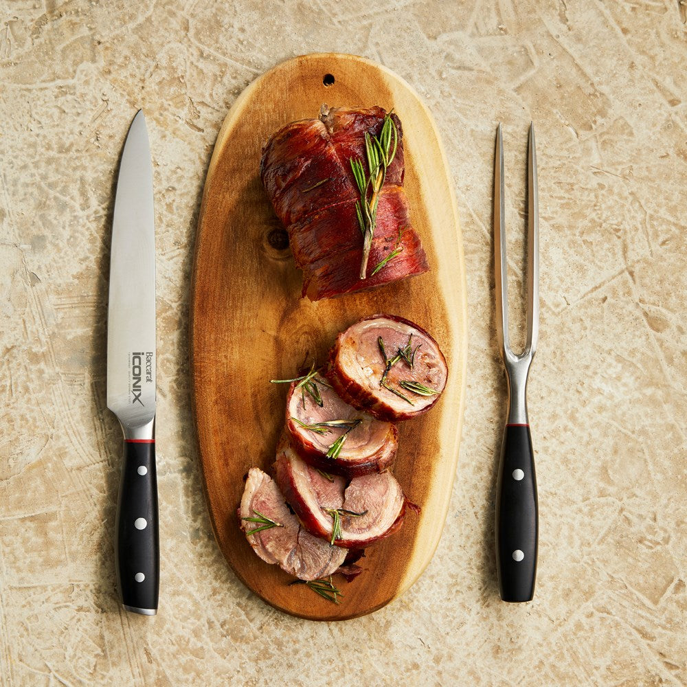 Sleek black-handled carving knife with silver blade beside its Baccarat packaging - Baccarat Iconix