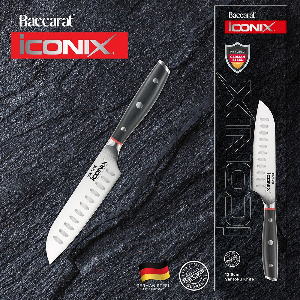 A sleek utility knife with a black handle beside sliced figs on a light surface - Baccarat Iconix