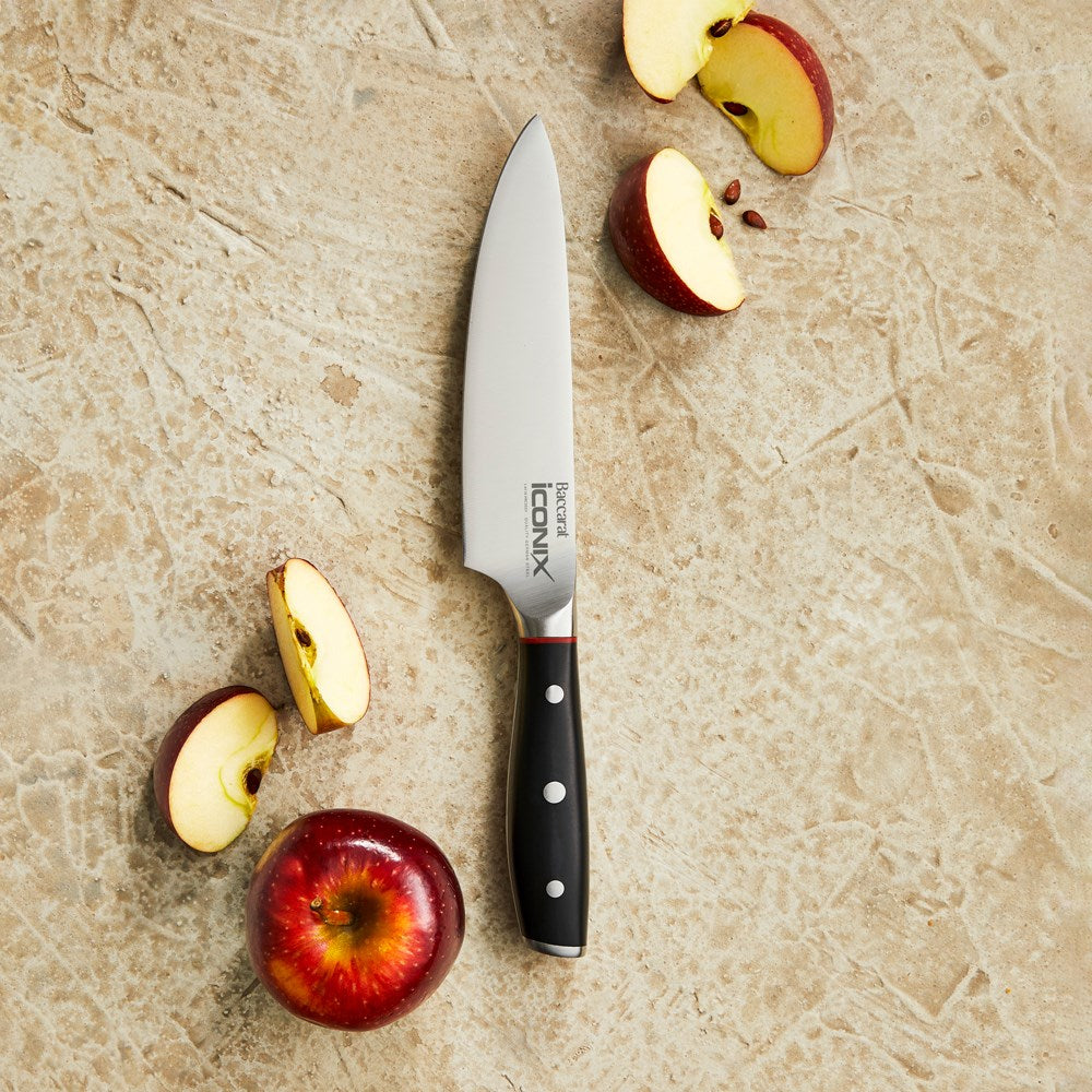 Black-handled chef's knife with red accents on a textured surface 15cm mini chef knife - Baccarat