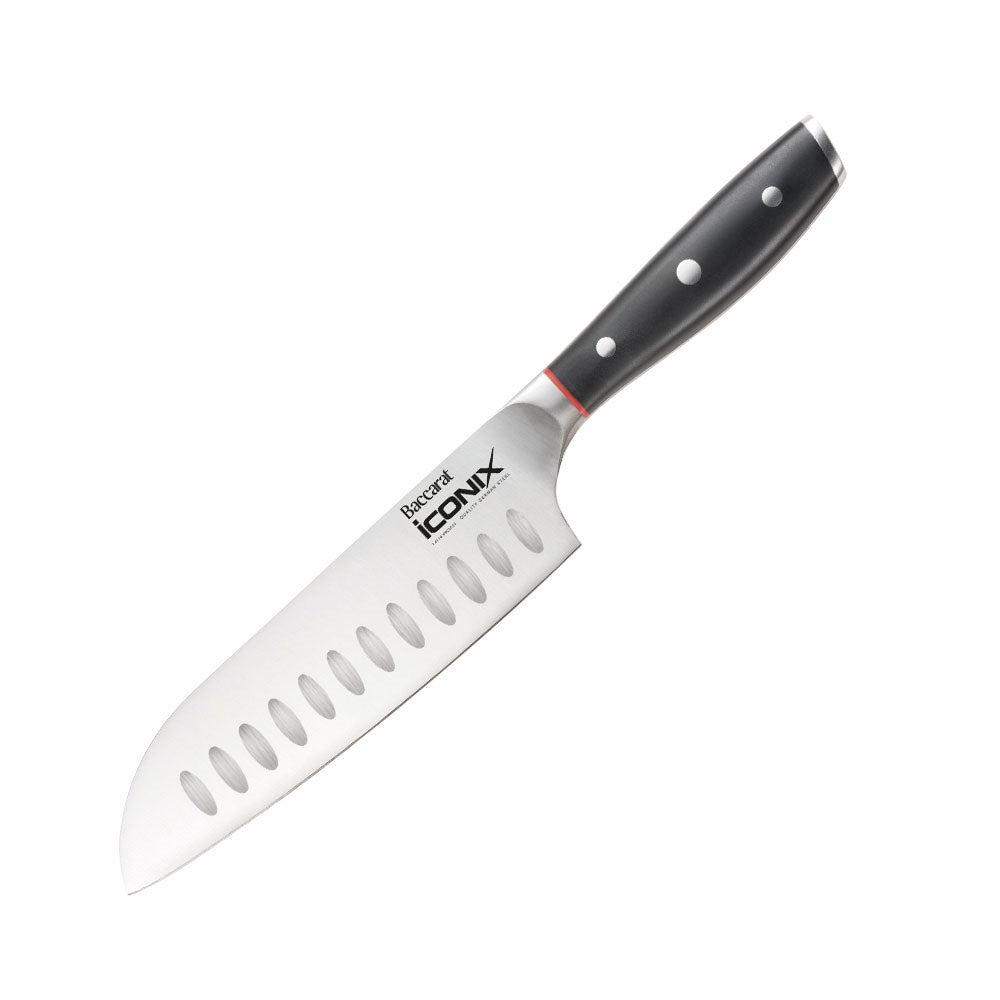 A sleek Baccarat Iconix Santoku Knife with a black handle and silver blade beside its packaging