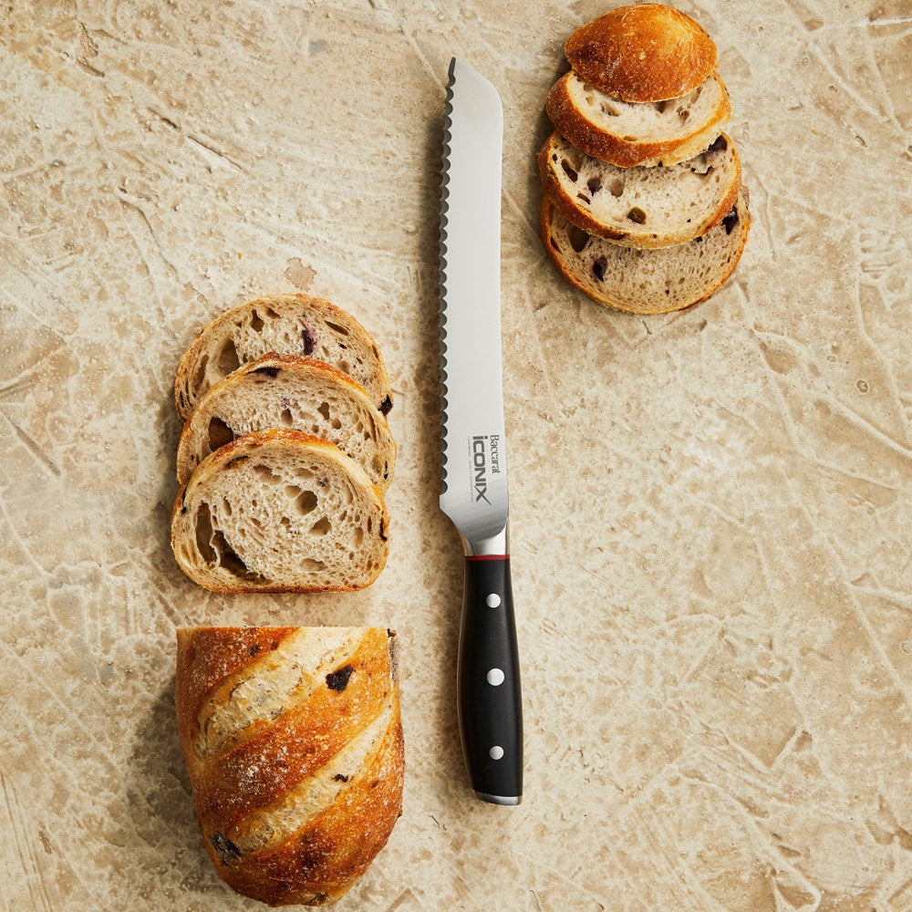 A serrated bread knife with a black handle next to black and red packaging bread knife 20cm - Iconix