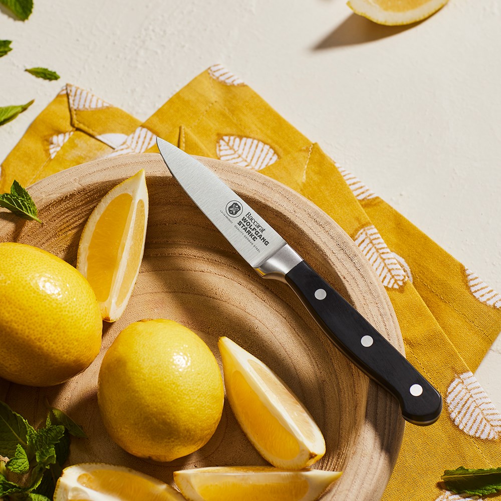 Stainless steel paring knives with a black handle by fresh figs and herbs - Baccarat Wolfgang Starke