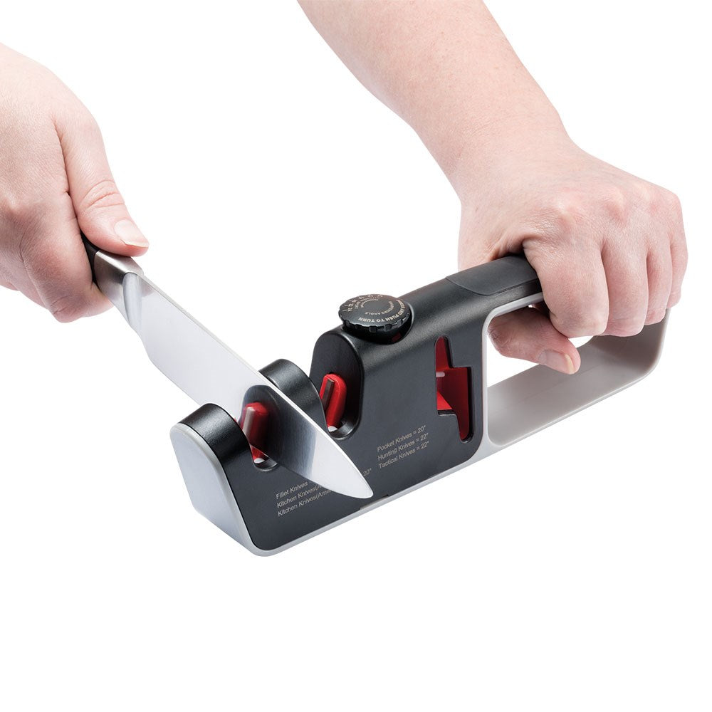 Person sharpening a knife with a black and red santoku knife 18cm - Baccarat wolfgang starke