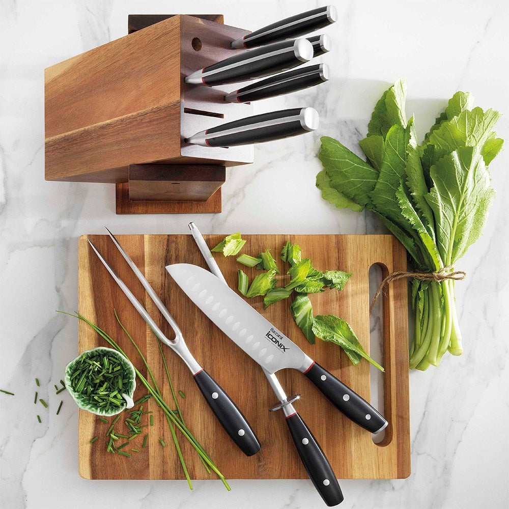 Wooden knife block with 9-piece black-handled knives on marble with herbs on cutting board- Baccarat