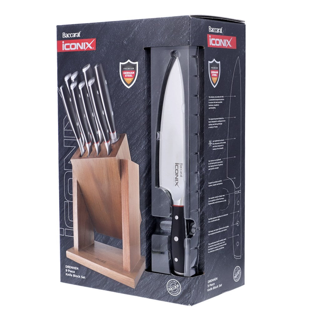 Wooden knife block with 9-piece black-handled knives on marble with herbs on cutting board- Baccarat