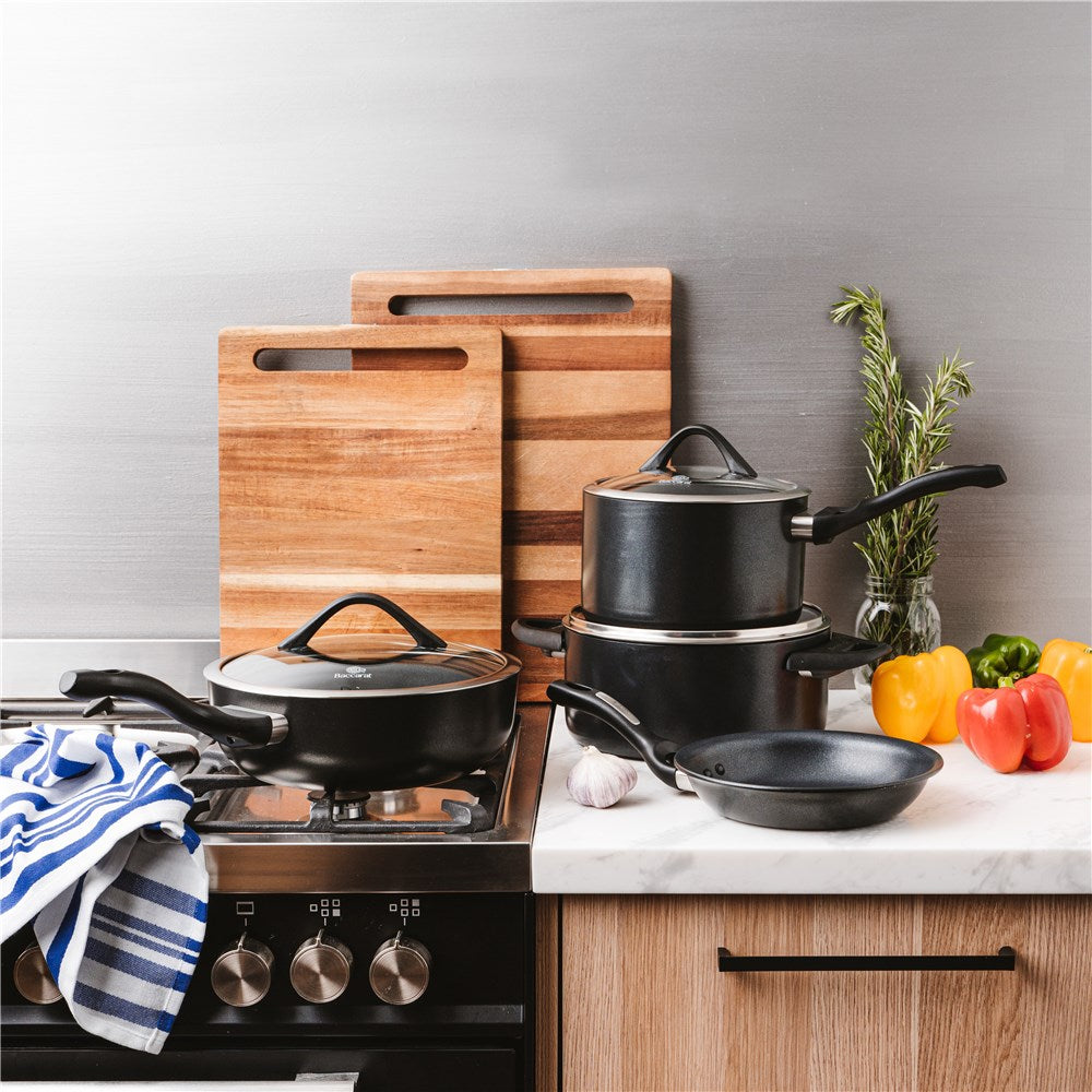 Modern kitchen with pans cutting boards and colourful peppers black cookware knife block - Baccarat