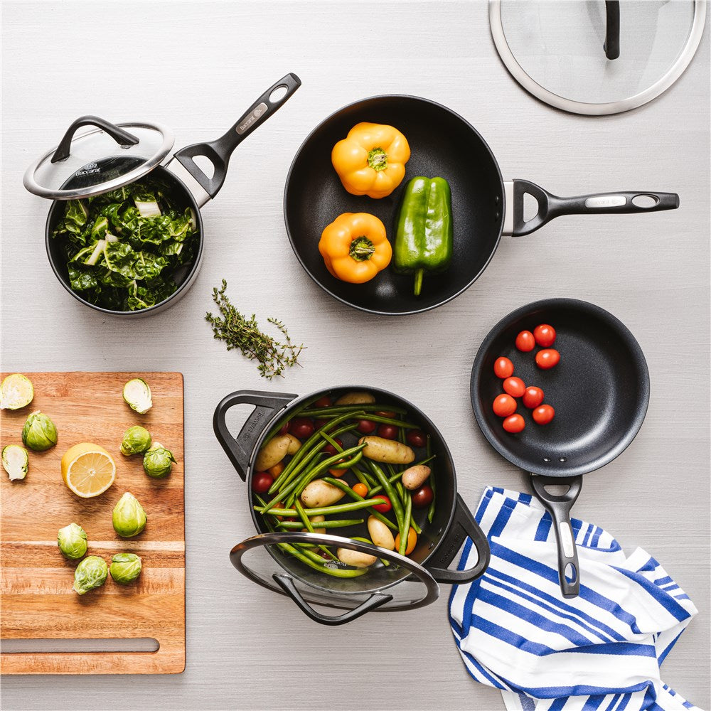 Modern kitchen with pans cutting boards and colourful peppers black cookware knife block - Baccarat