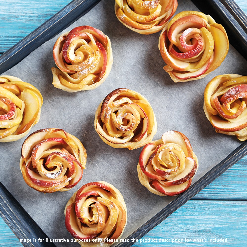 Top view of a baking tray with golden-brown rose-shaped apple pastries on parchment paper - Baccarat