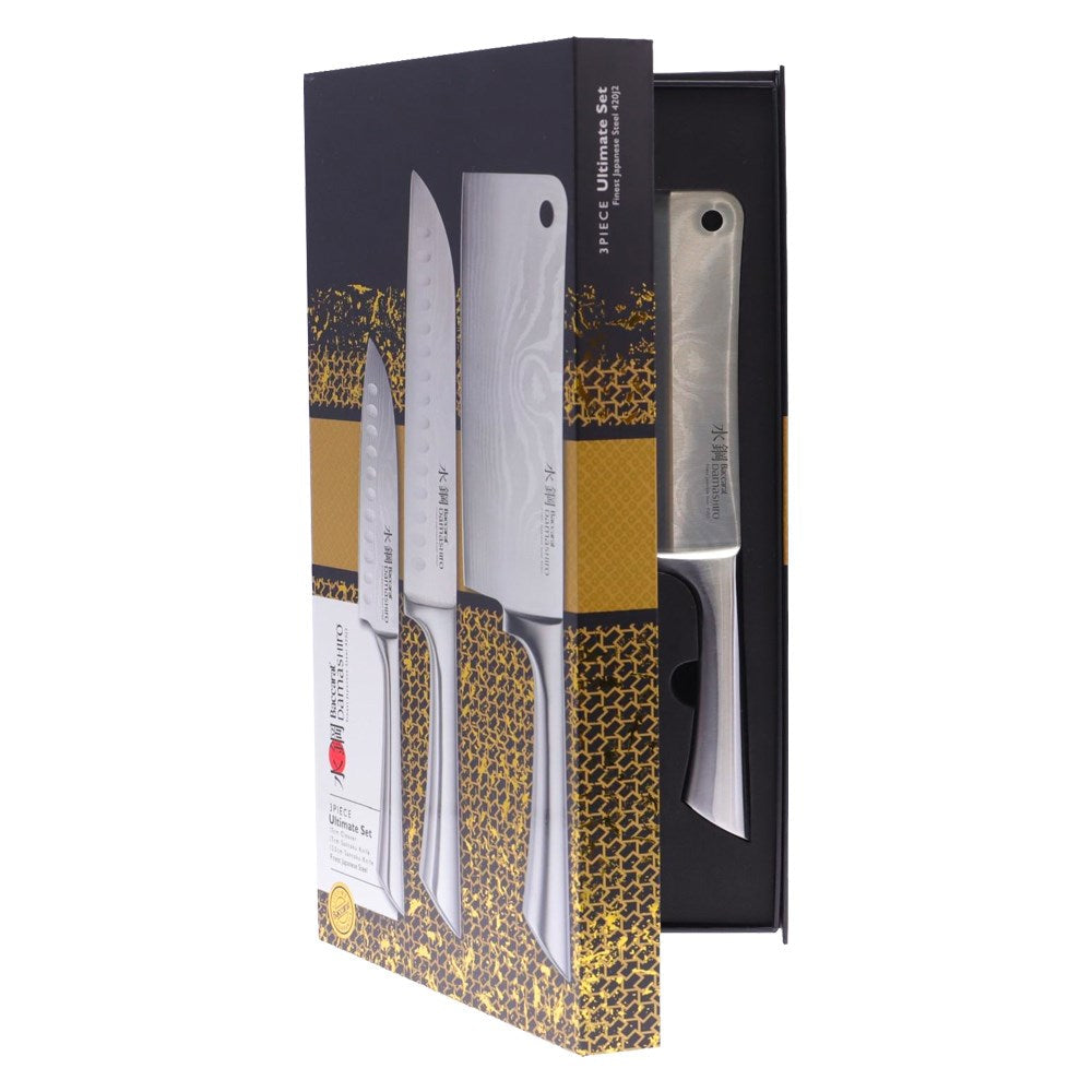 Three stainless steel knives next to whole and sliced limes grey surface - Baccarat Damashiro