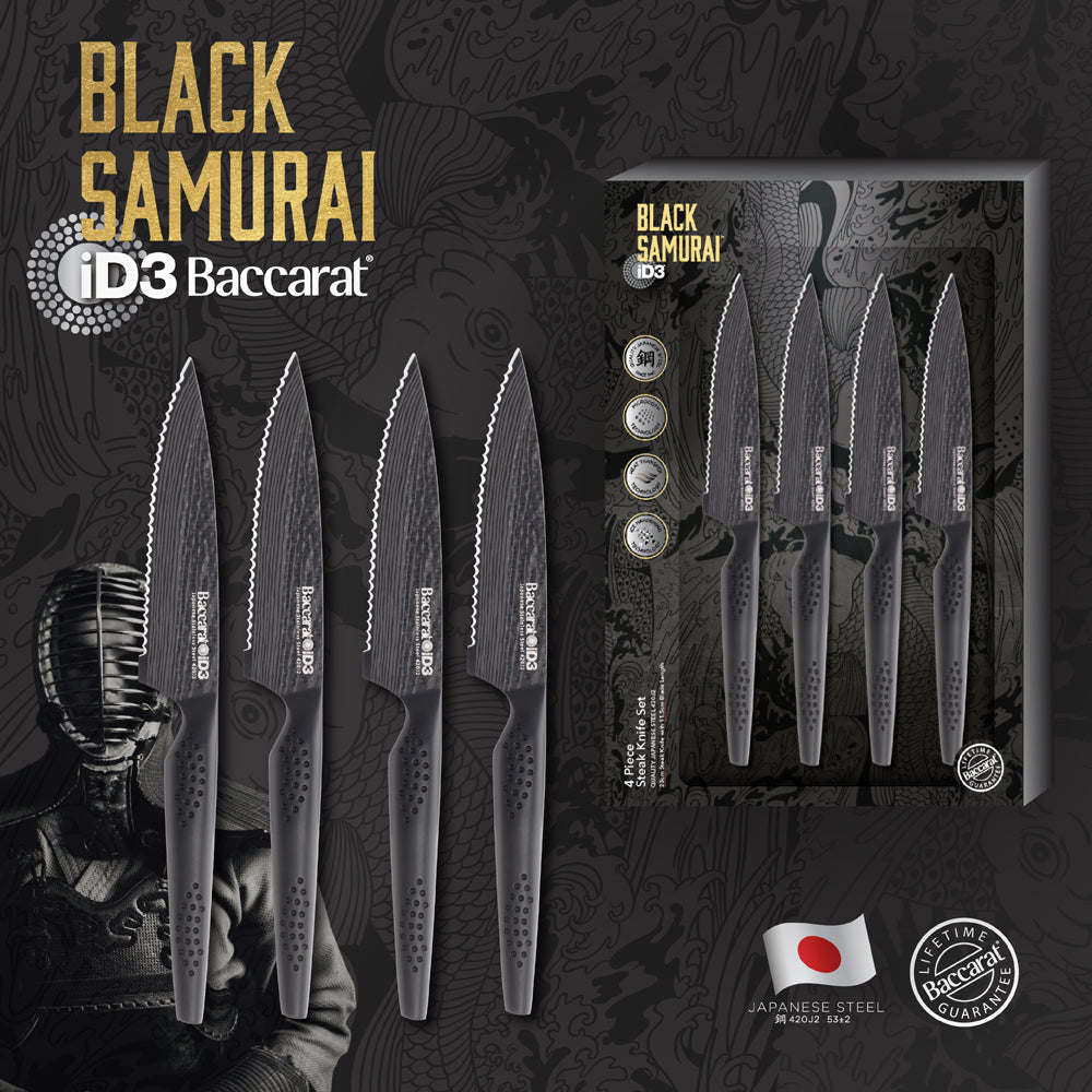 Elegant Baccarat Samurai Set of 4-piece steak knives lined up on dark slate with herbs and spices