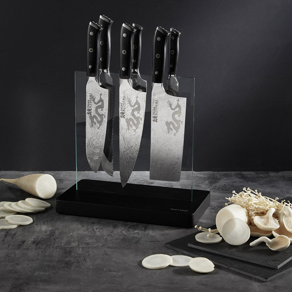 Sleek stainless steel knives next to sliced mushrooms and garlic premium black handles - Baccarat