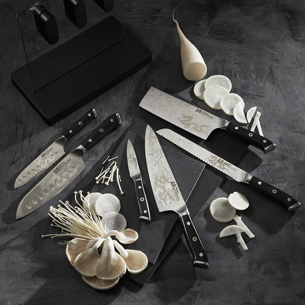 Sleek stainless steel knives next to sliced mushrooms and garlic premium black handles - Baccarat