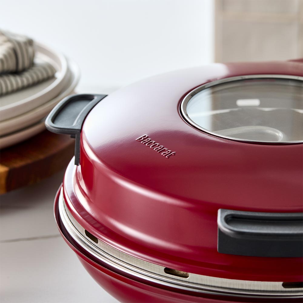 Red gourmet slice pizza oven with temperature dial beside a plant and tomato sauce bottle - Baccarat