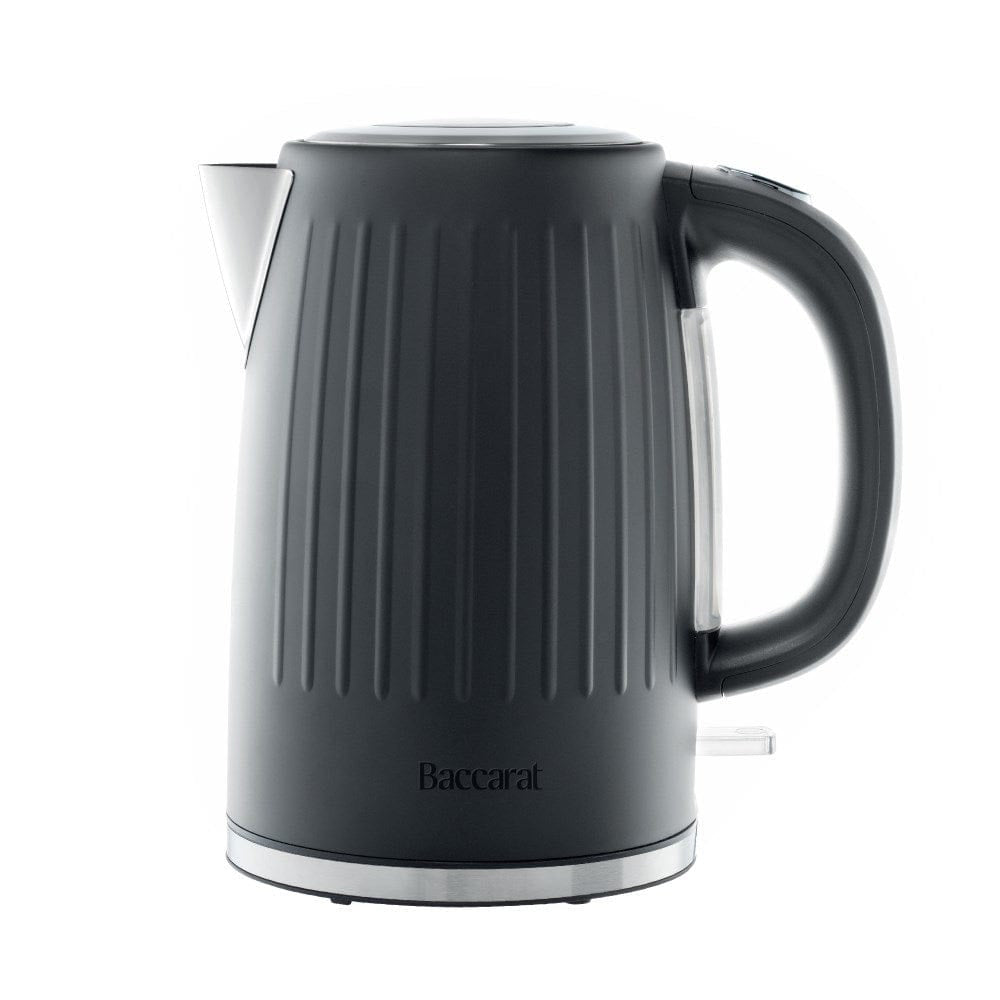 Black kettle pours hot water into a white cup beside a pastry plate - Baccarat Boiling Point Kettle