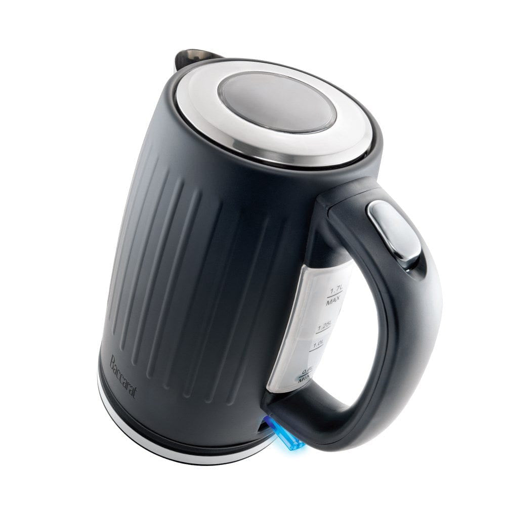 Black kettle pours hot water into a white cup beside a pastry plate - Baccarat Boiling Point Kettle