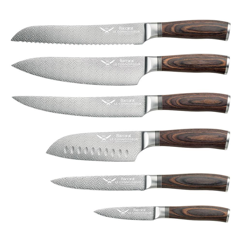 Chef's knife slicing garlic on a kitchen counter shiny silver blade 7 piece knife block - Baccarat