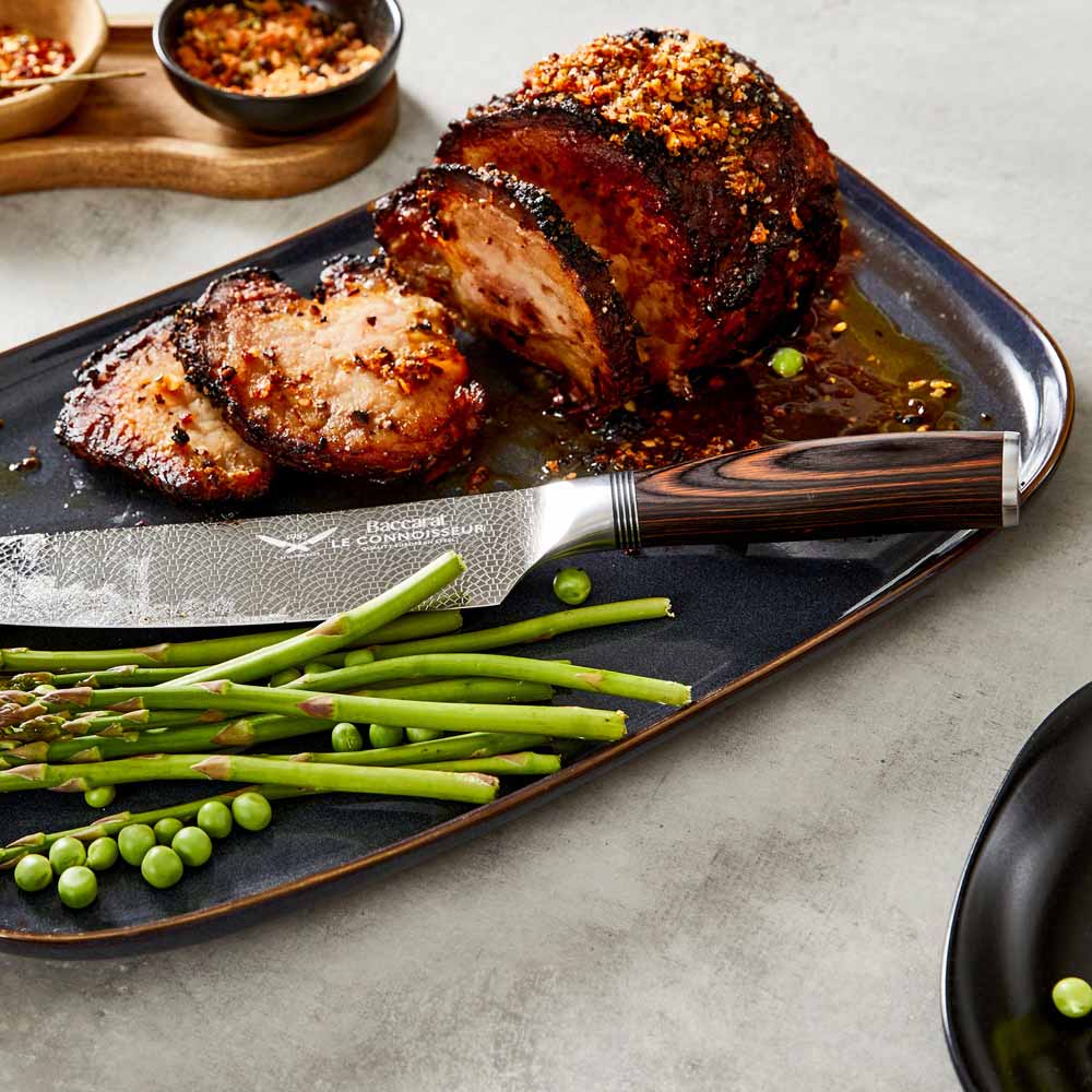 Chef's knife slicing garlic on a kitchen counter shiny silver blade 7 piece knife block - Baccarat