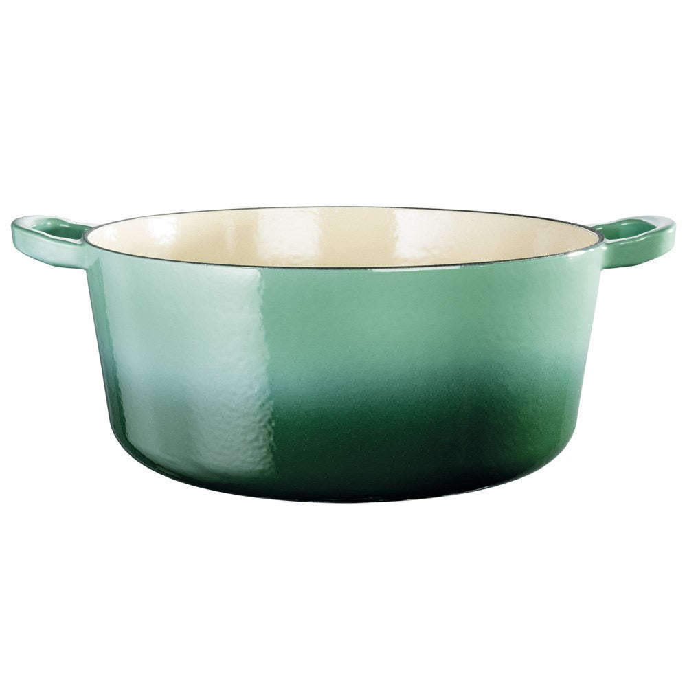 Green Baccarat Le Connoisseur French Oven with lid on countertop surrounded by herbs and a plant
