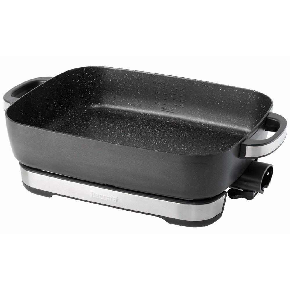A black pan of bread pudding with a bowl of ice cream on a white countertop black frypan - Baccarat