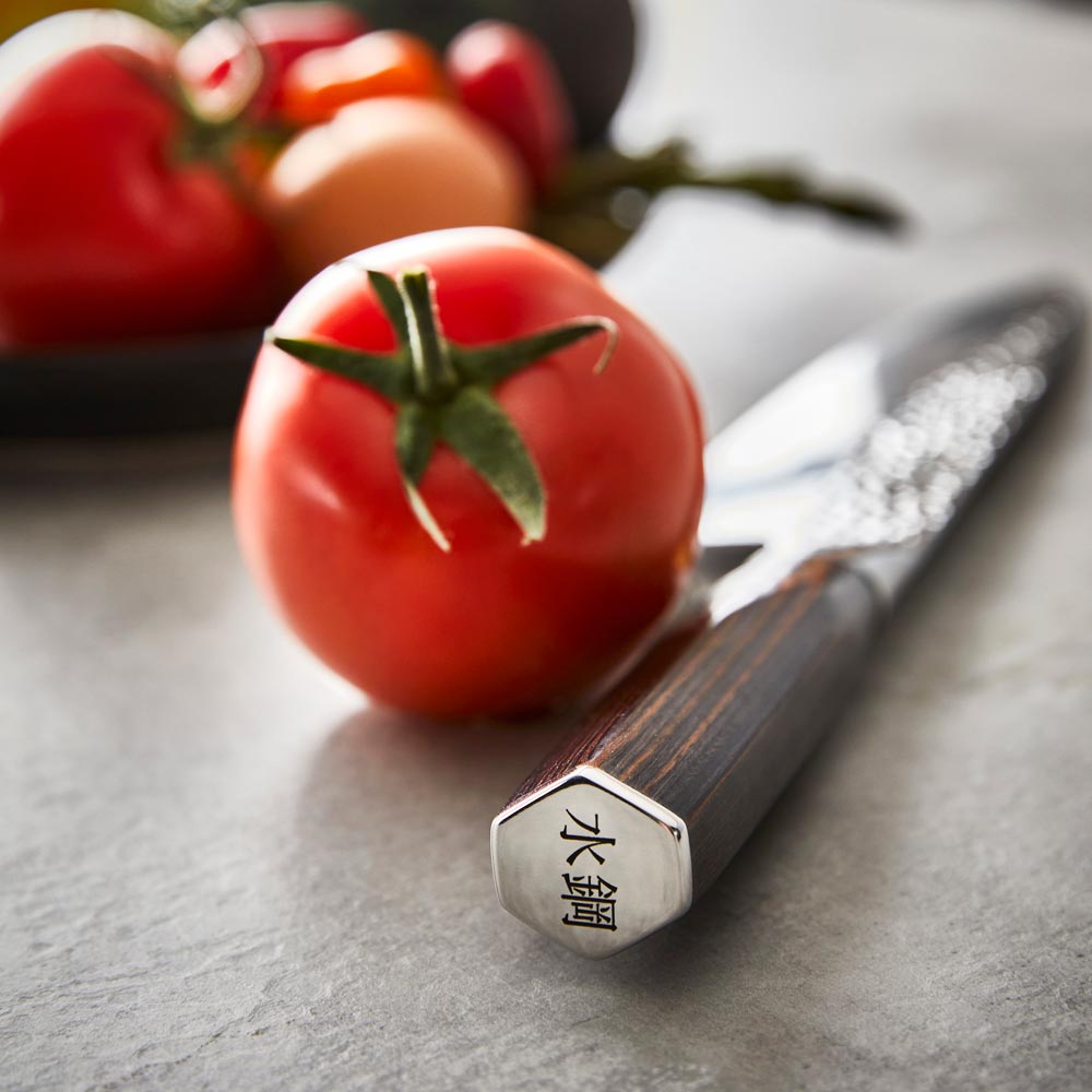 Sharp kitchen knives surround a colourful salad with eggs on a gray surface - Damashiro Emperor Hisa