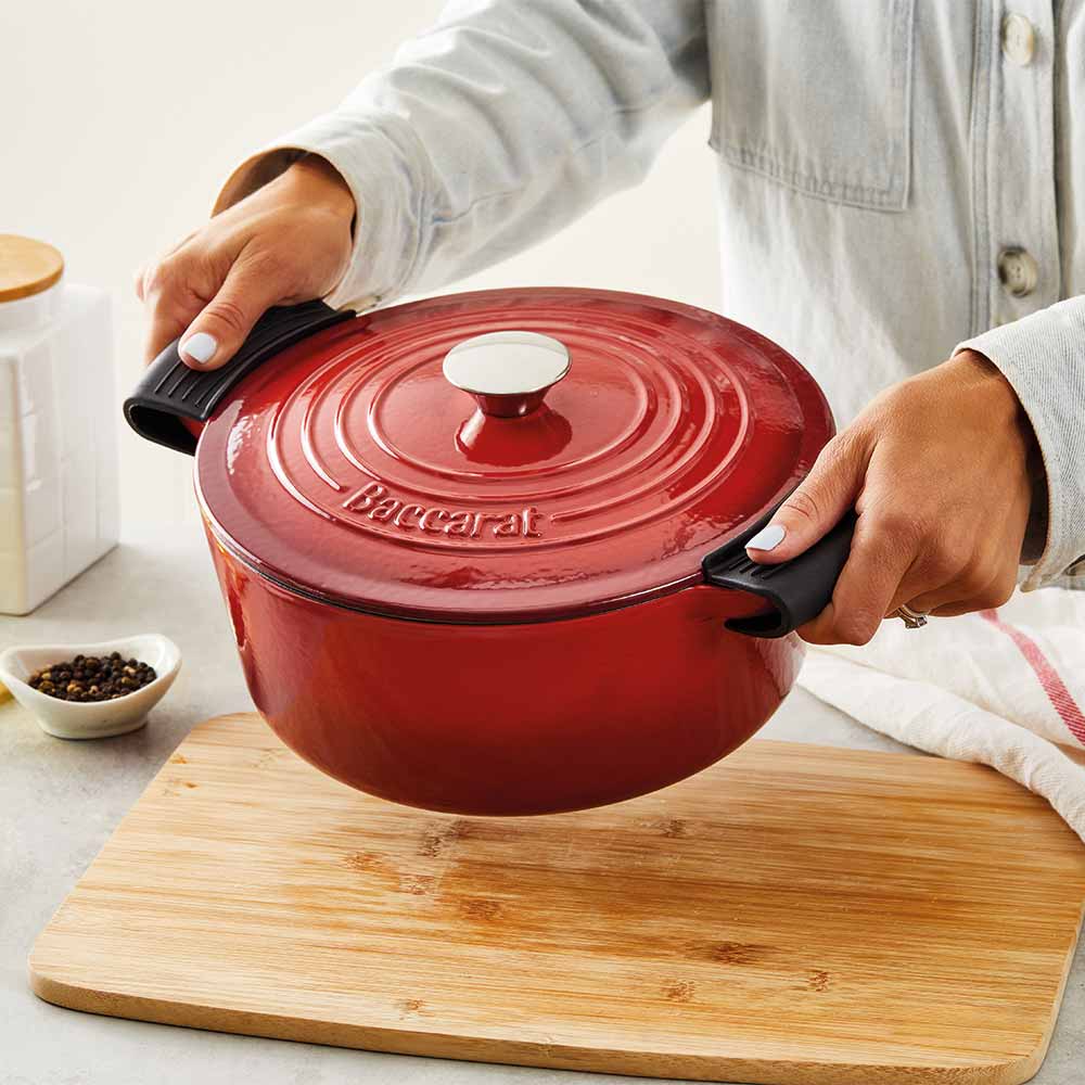 A hand grips a black handle of a teal spoon rest - teal spoon rest - Baccarat le connoisseur