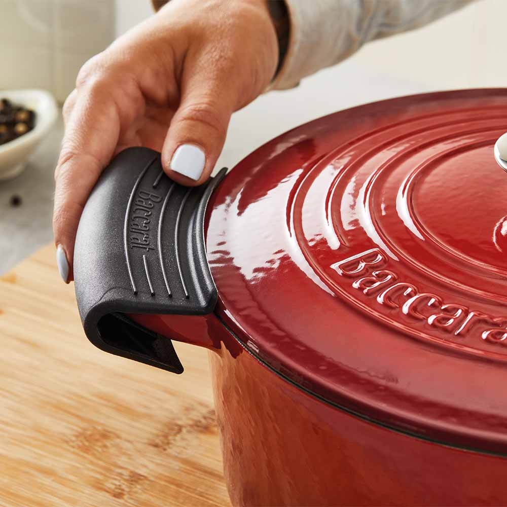 A hand grips a black handle of a teal spoon rest - teal spoon rest - Baccarat le connoisseur