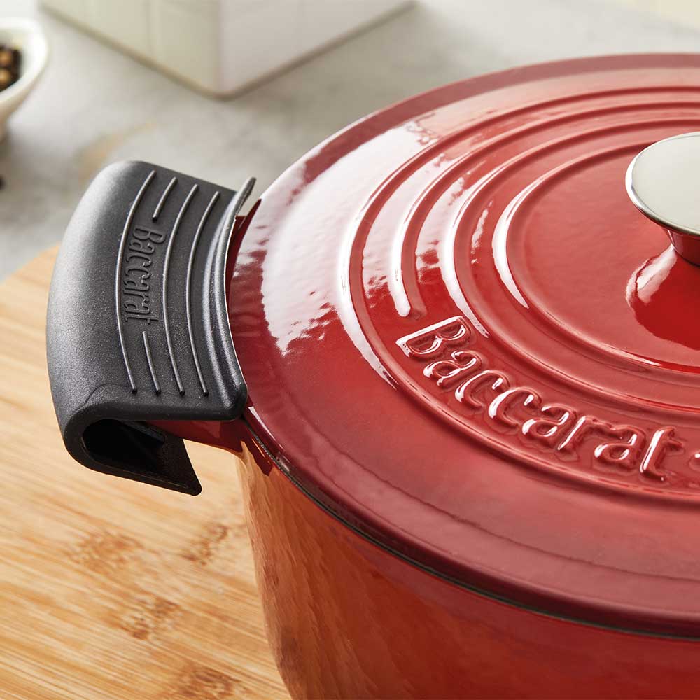 A hand grips a black handle of a teal spoon rest - teal spoon rest - Baccarat le connoisseur