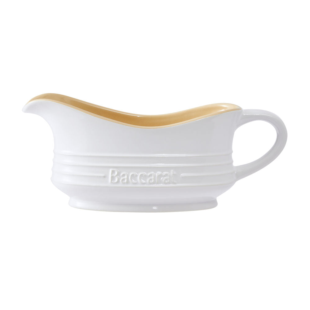 A white ceramic gravy boat with a light brown interior featuring an elegant handle design - Baccarat