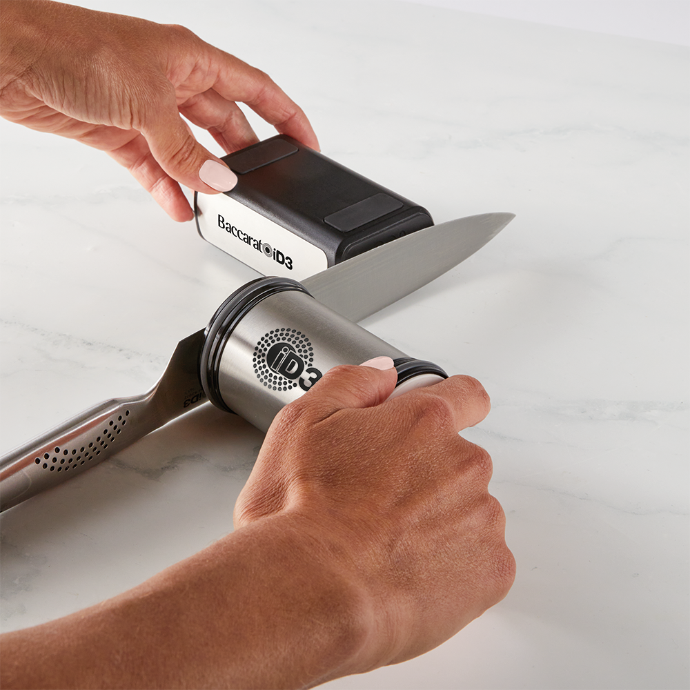 Hand sharpening a large kitchen knife on a gray sharpening stone gray knife sharpener - Baccarat