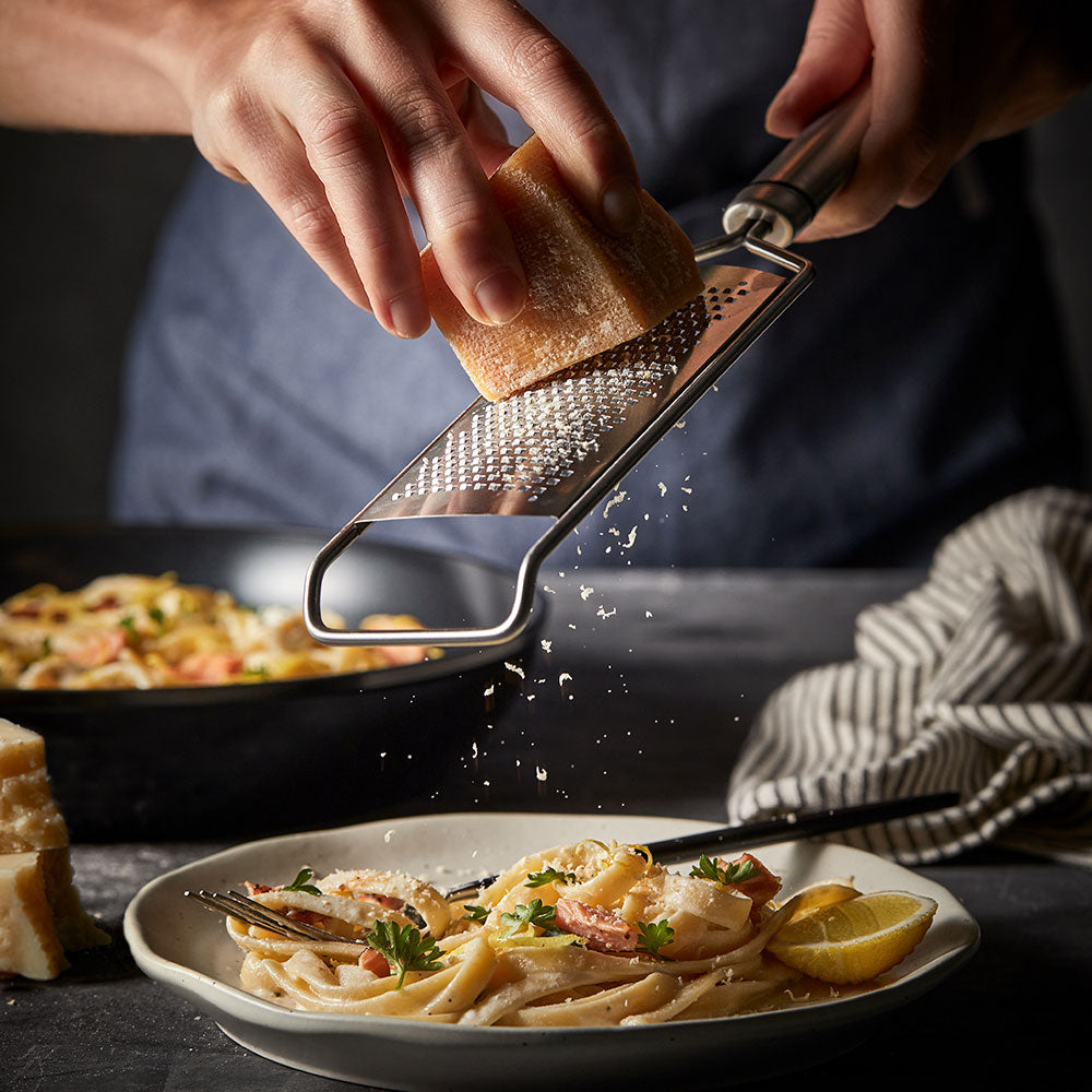 Creamy pasta with herbs on a white plate with parmesan wedge and non stick frypan 20cm - Baccarat