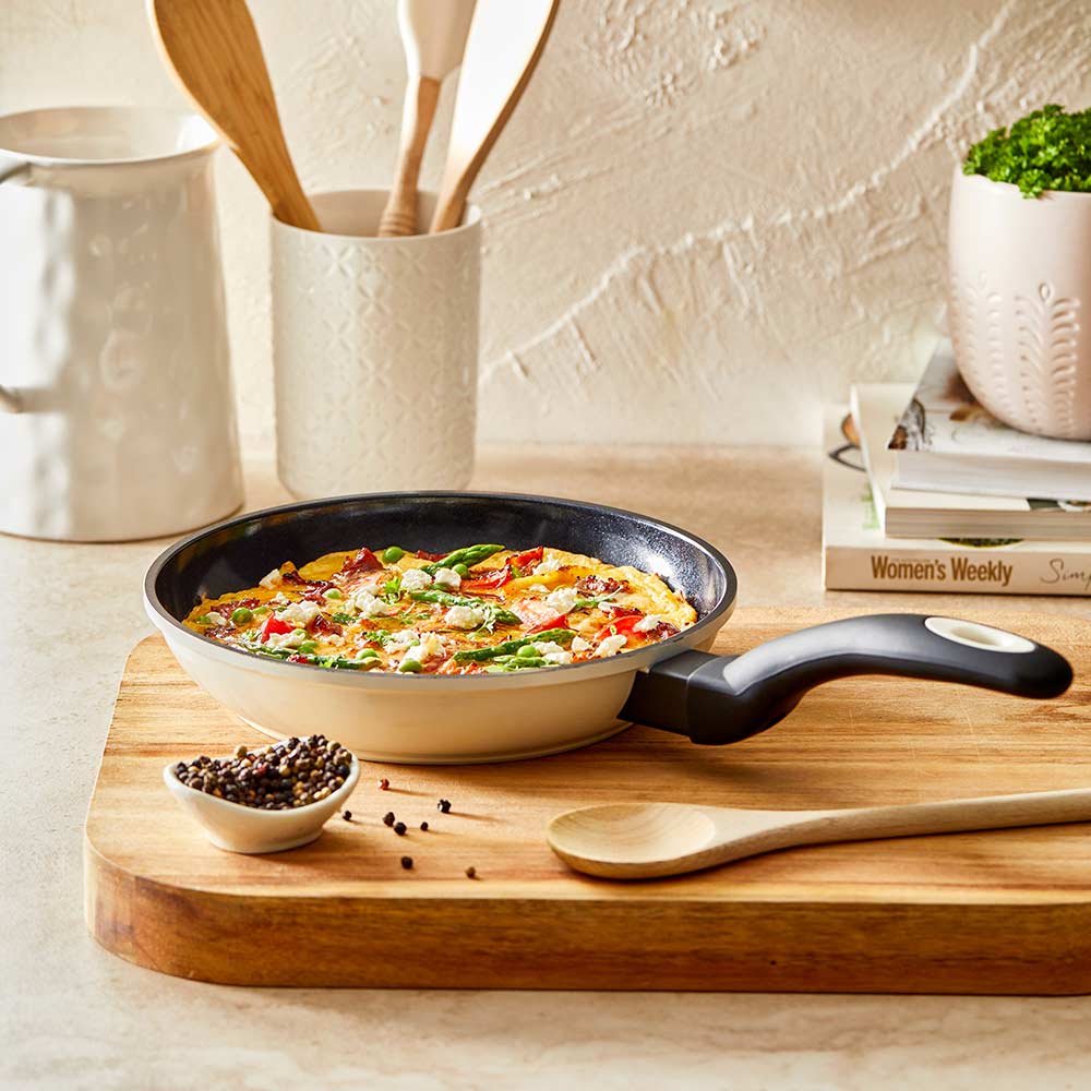 Aerial view of a black non-stick frying pan with a long handle cream non-stick frying pan - Baccarat