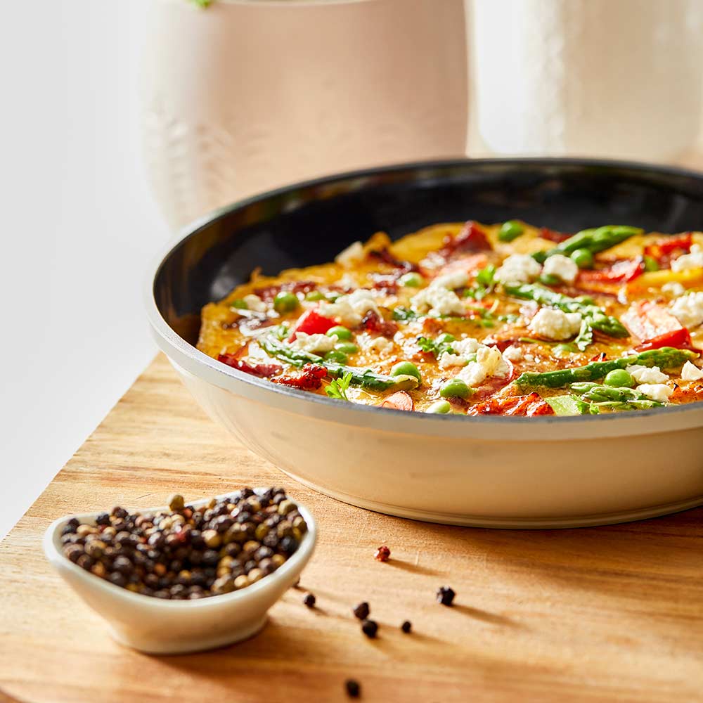 Aerial view of a black non-stick frying pan with a long handle cream non-stick frying pan - Baccarat
