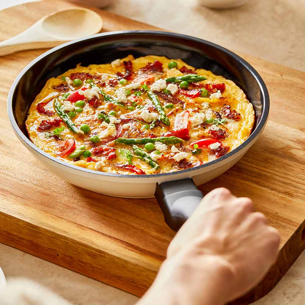 Aerial view of a black non-stick frying pan with a long handle cream non-stick frying pan - Baccarat