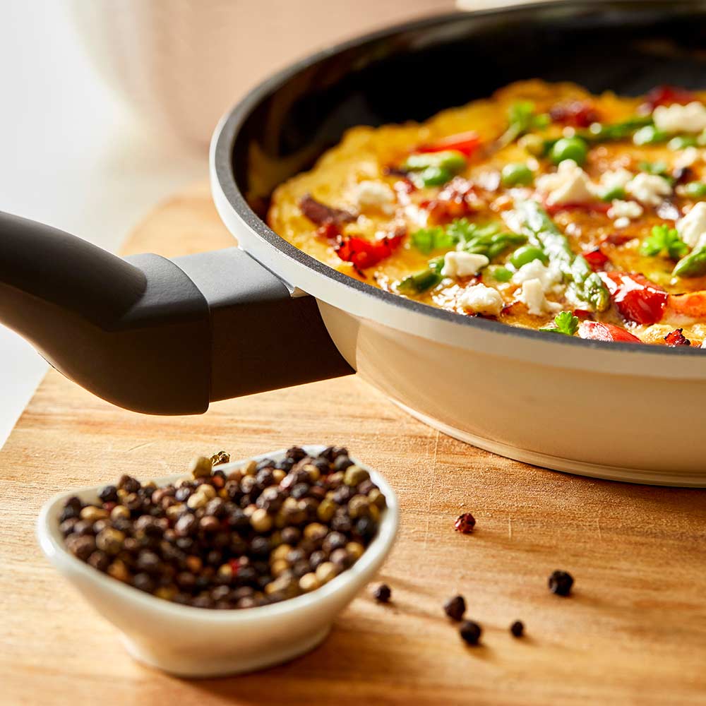 Aerial view of a black non-stick frying pan with a long handle cream non-stick frying pan - Baccarat