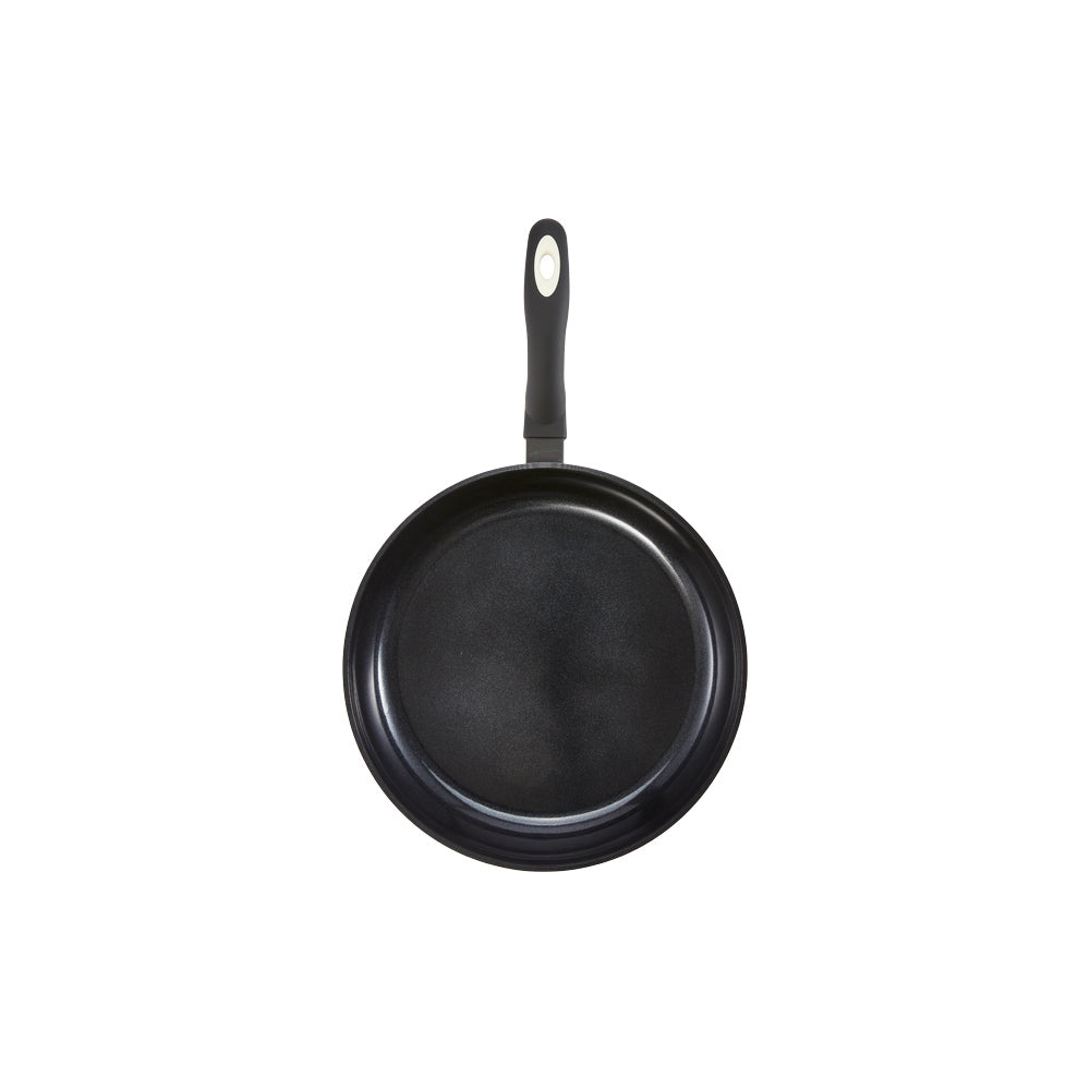 A 32-cm Baccarat Bio Frying pan containing pasta on a wooden board surrounded by fresh ingredients