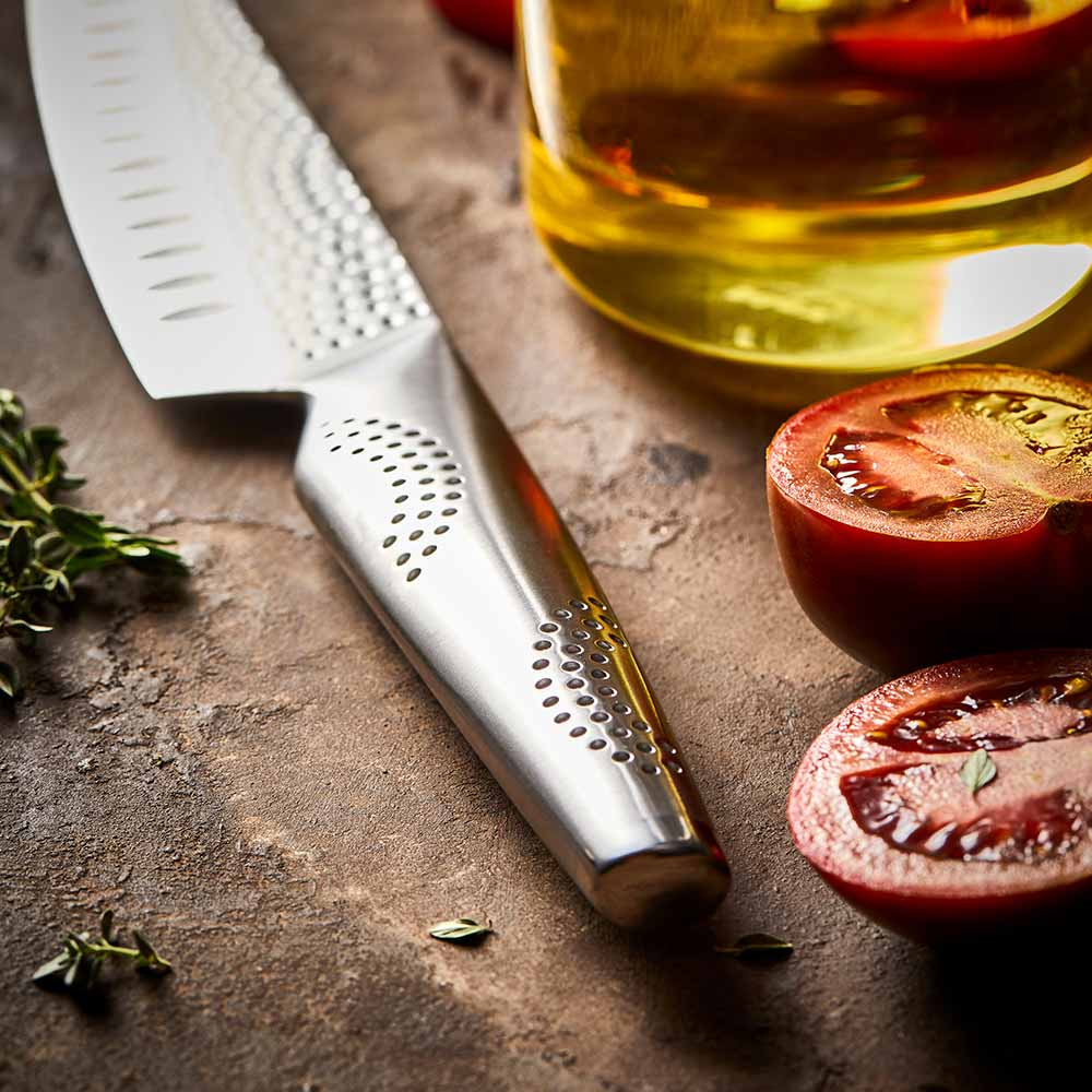 Fresh tomatoes in a wooden bowl with a silver knife on a brown surface - 11cm knife Samurai Santoku