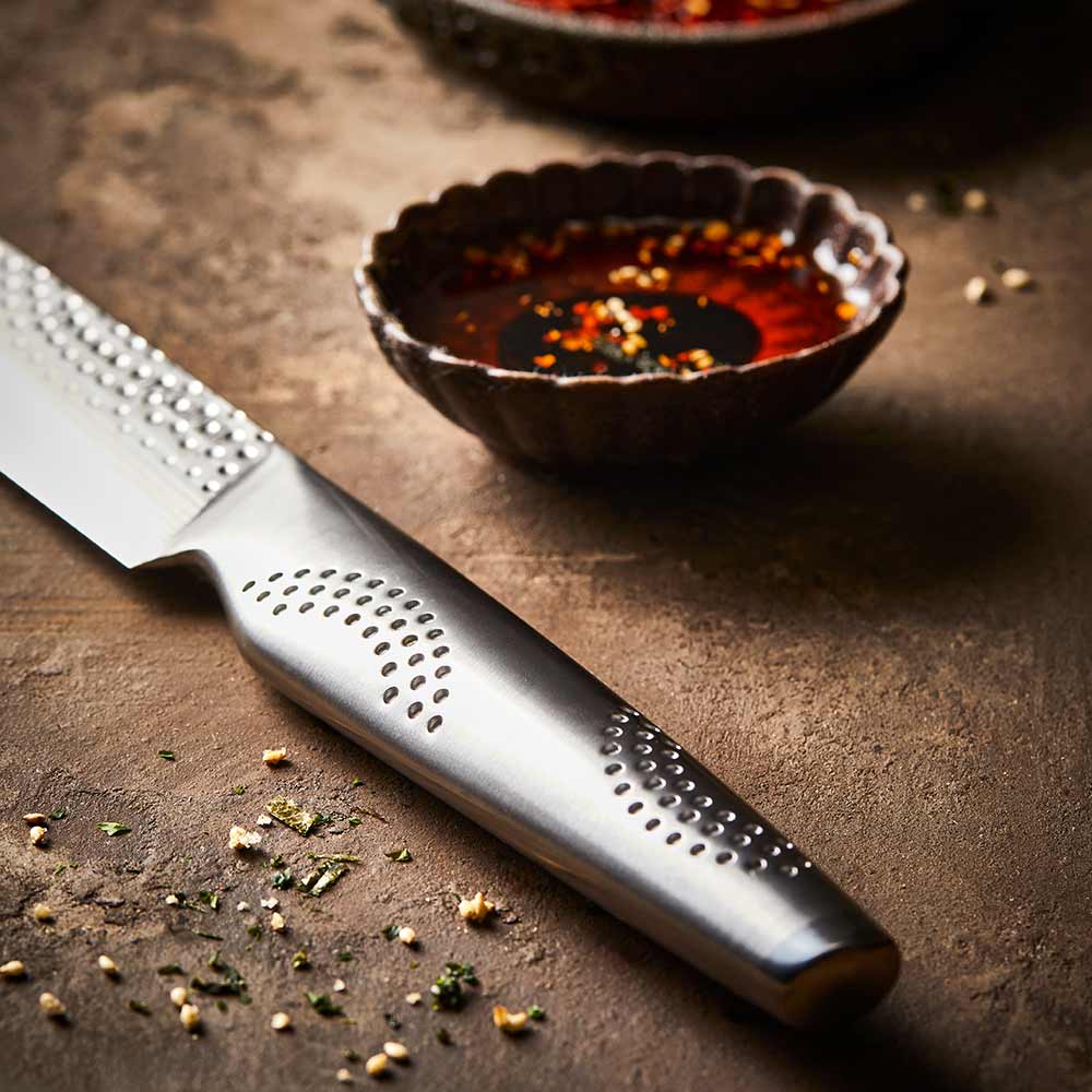 A sharp knife rests beside sliced raw fish on a slate board silver kitchen knife 20cm - Baccarat