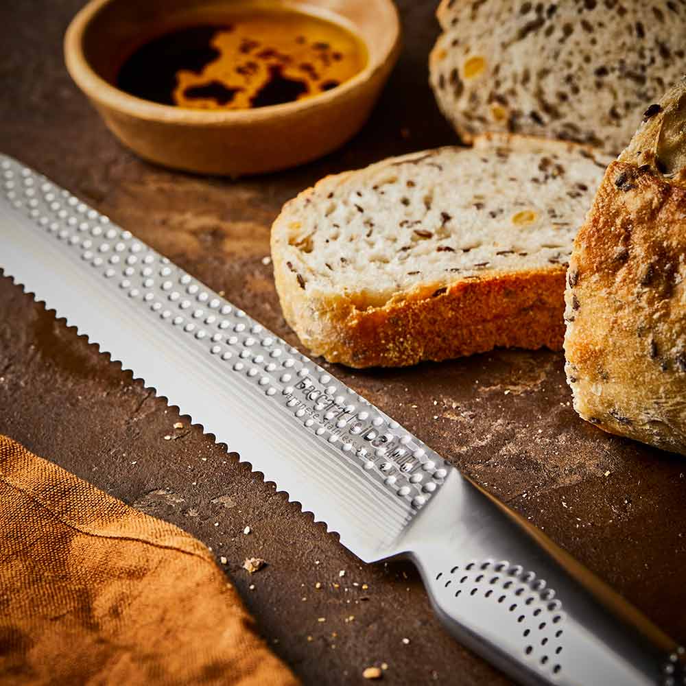 Close-up of serrated knife with sliced multigrain bread on wooden board silver knife 20cm - Baccarat