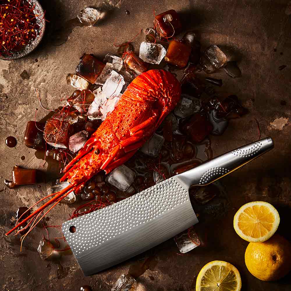 Steel knife with intricate patterns next to a red lobster on ice Samurai bread knife 20cm - Baccarat