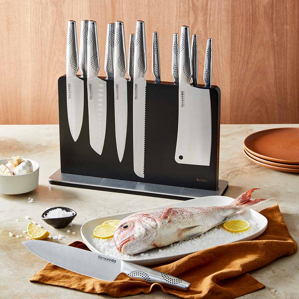 A close-up of a silver stainless steel knife on a wooden cutting board stainless steel knife - Kachi