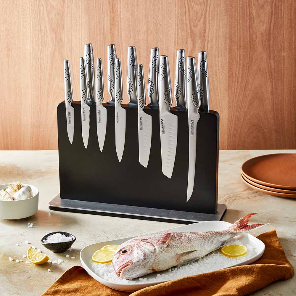 A close-up of a silver stainless steel knife on a wooden cutting board stainless steel knife - Kachi