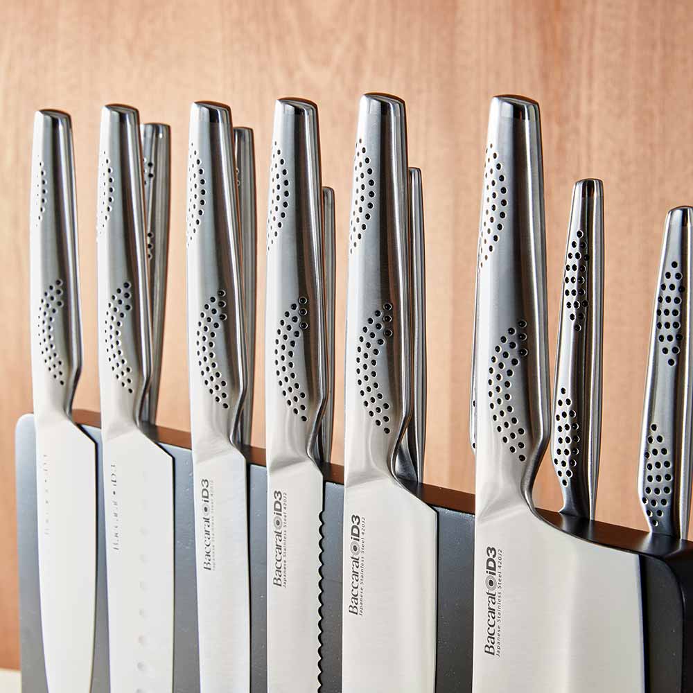 A close-up of a silver stainless steel knife on a wooden cutting board stainless steel knife - Kachi