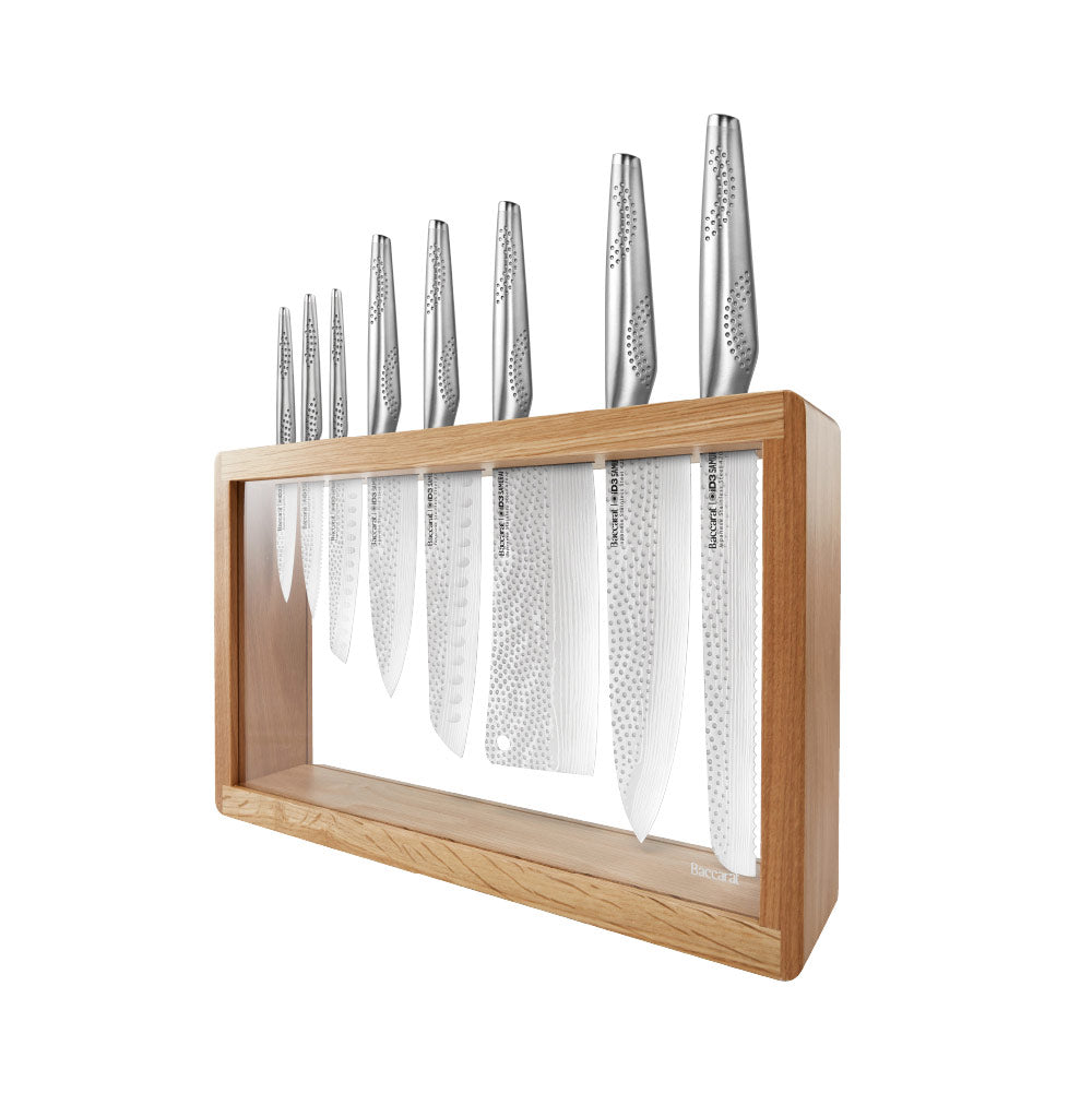 A set of fourteen sleek silver kitchen knives neatly arranged stainless steel knife block - Baccarat