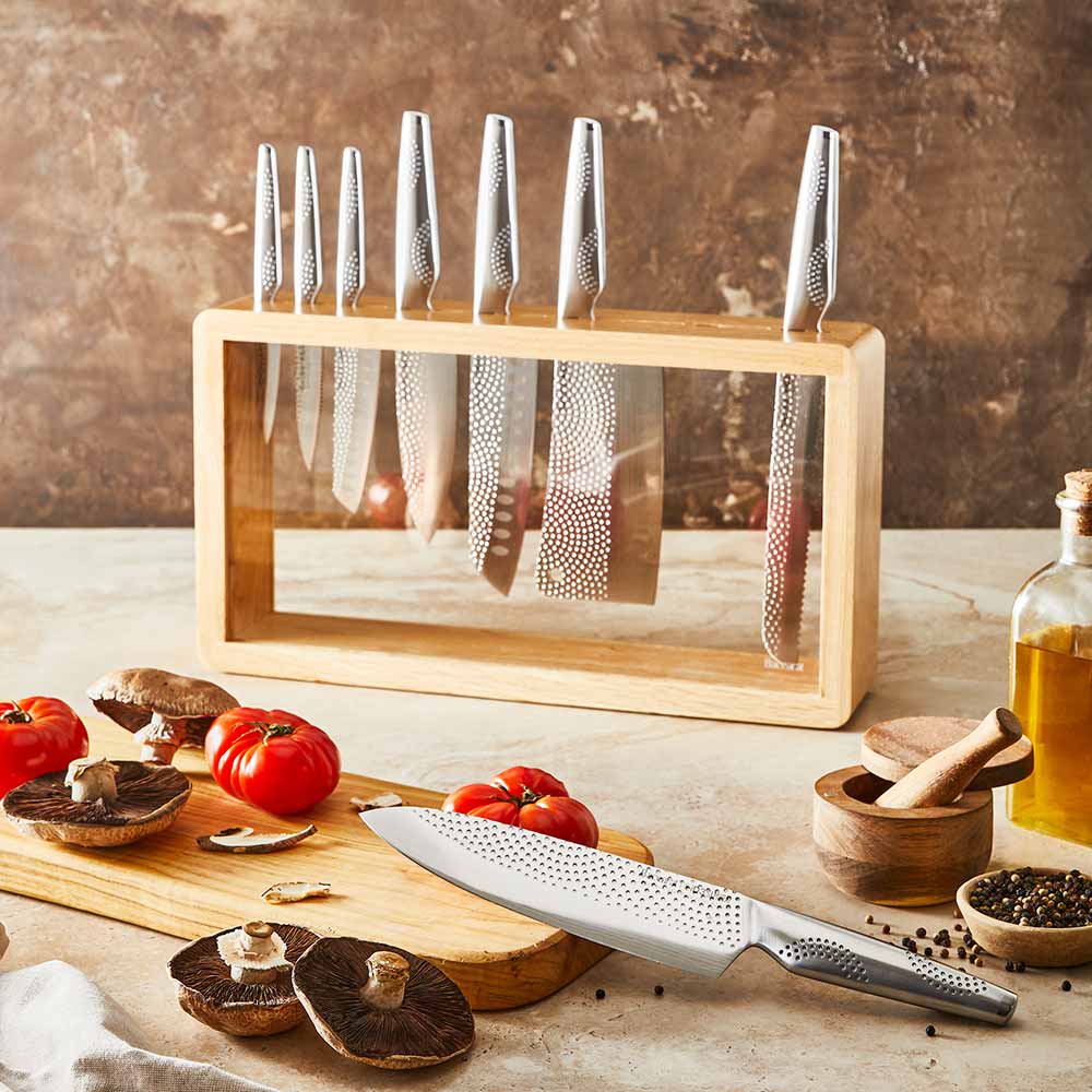 A set of fourteen sleek silver kitchen knives neatly arranged stainless steel knife block - Baccarat