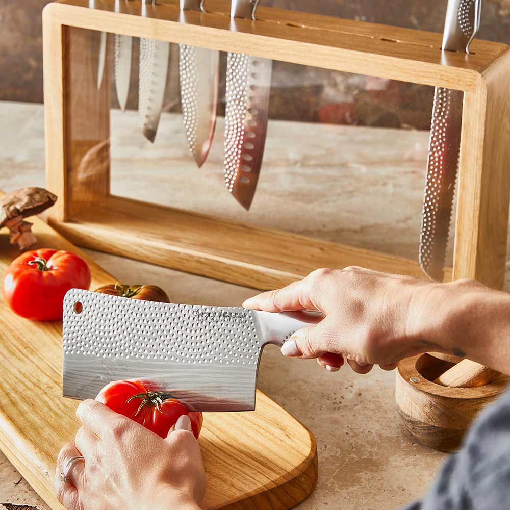 A set of fourteen sleek silver kitchen knives neatly arranged stainless steel knife block - Baccarat