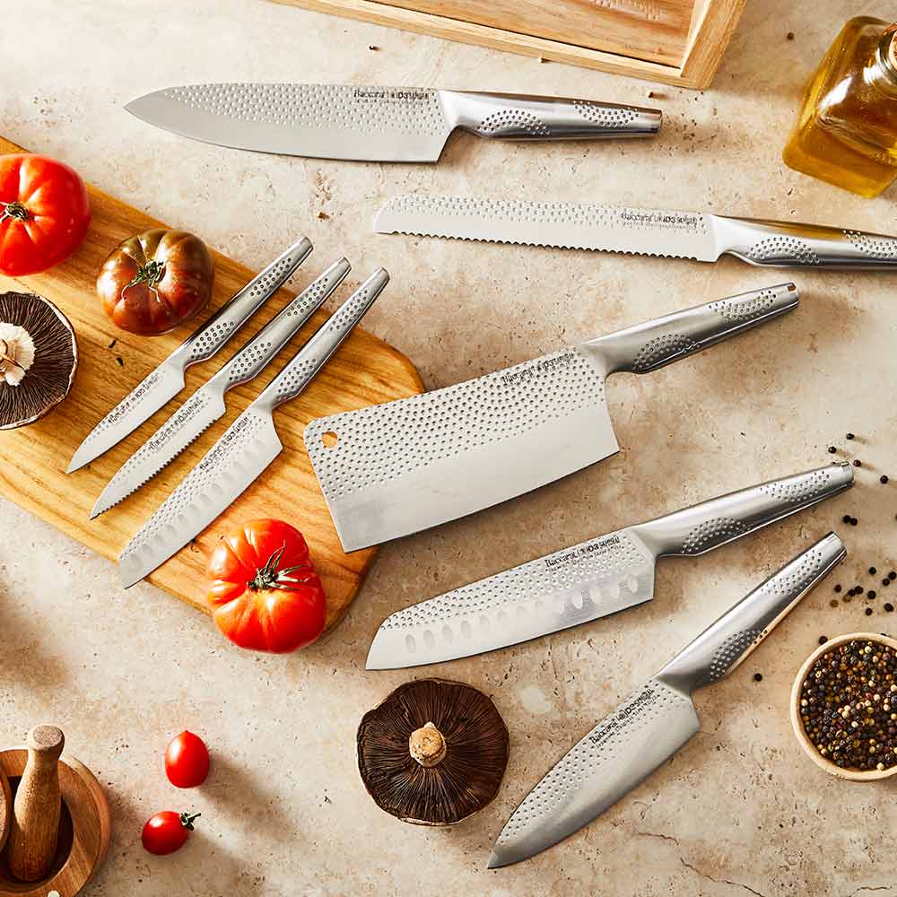 A set of fourteen sleek silver kitchen knives neatly arranged stainless steel knife block - Baccarat