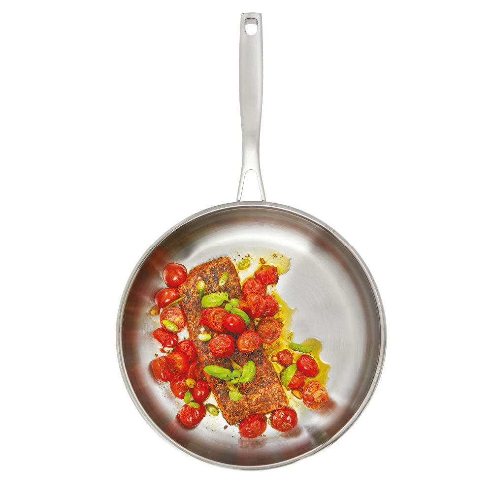A stainless steel frying pan with a textured handle sits on a wooden board - frypan 26cm - Baccarat